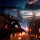 Image of Dragon Age 4 character sitting on a parapet with a glass of wine overlooking a brightly lit magical city.